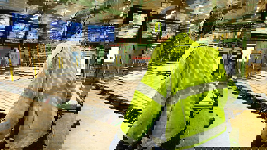 man kontrollerar träprodukter i sågverk