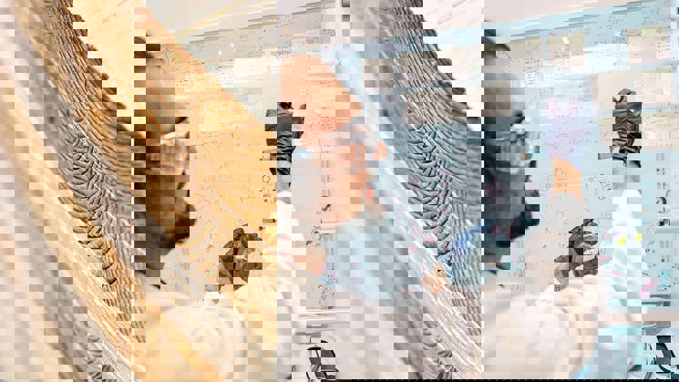 inzoomad bild på limträ och en man som arbetar i ett laboratorium