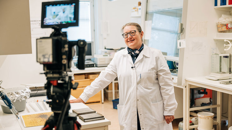 kvinna med vit rock står i laboratorium