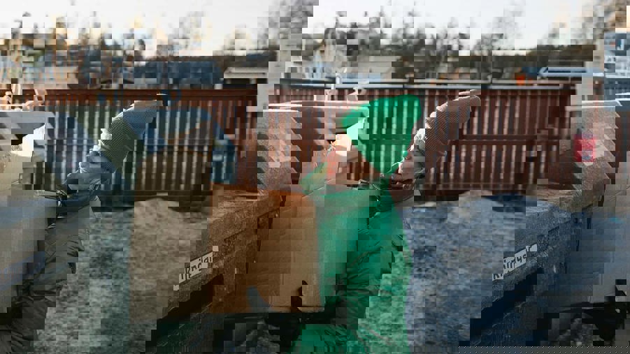 en kvinna står framför en återvinningsstation