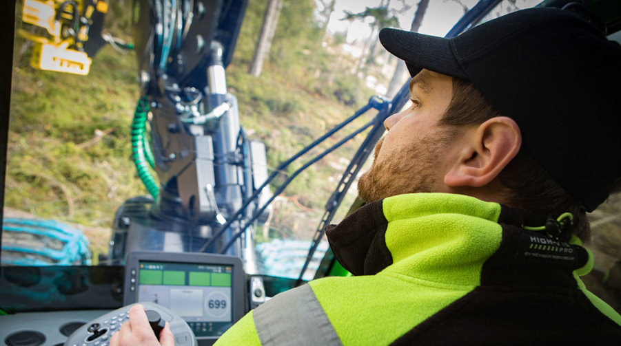 person sitter i en skördarmaskin