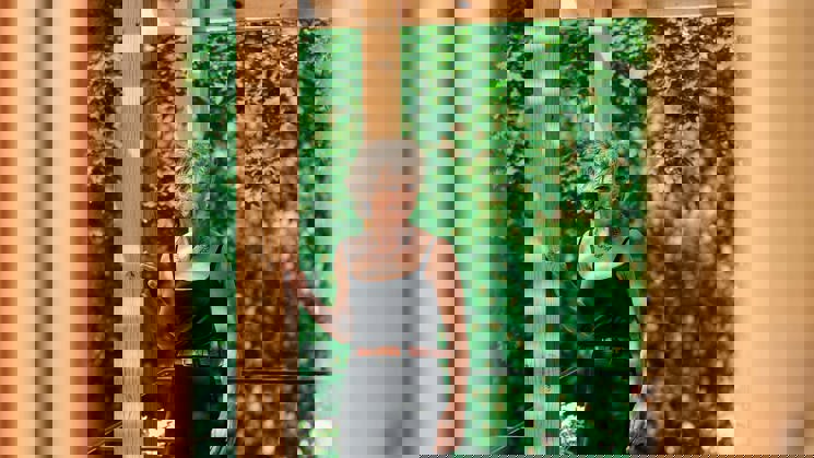 kvinna framför yogapaviljong i trä