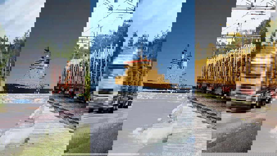 timmerlatbil, isbrytare och tåg lastat med timmer